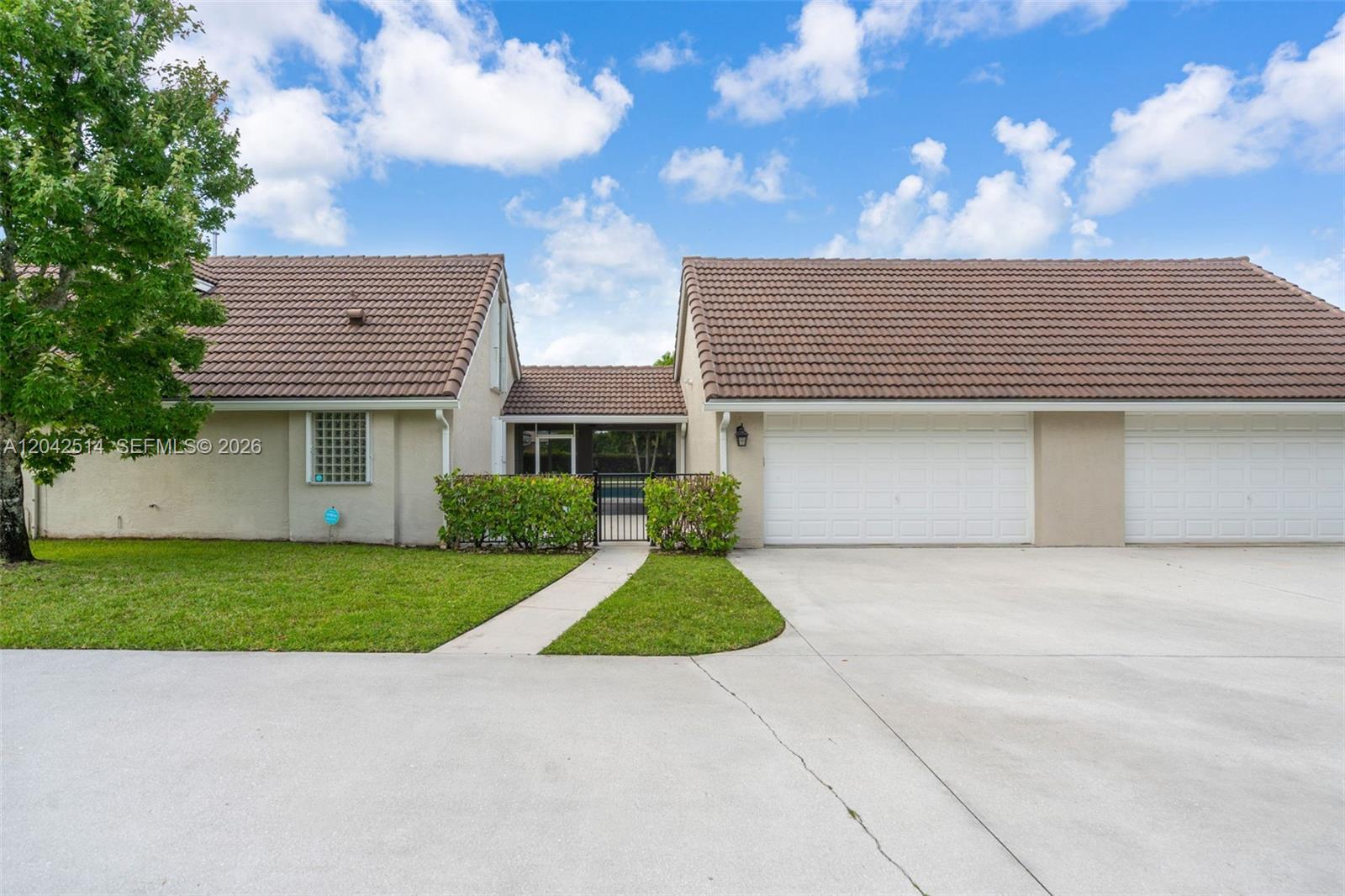 The exterior view shows a house with a brown tile roof, garage, and gated courtyard — 5703 Lago Del Sol Dr, Lake Worth FL 33449, LAKE WORTH, FL