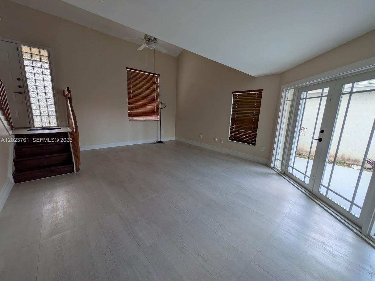 A modern living room features a dark gray sofa, coffee table, armchair, and a beverage refrigerator — 11740 SW 102nd St, Miami FL 33186, MIAMI, FL