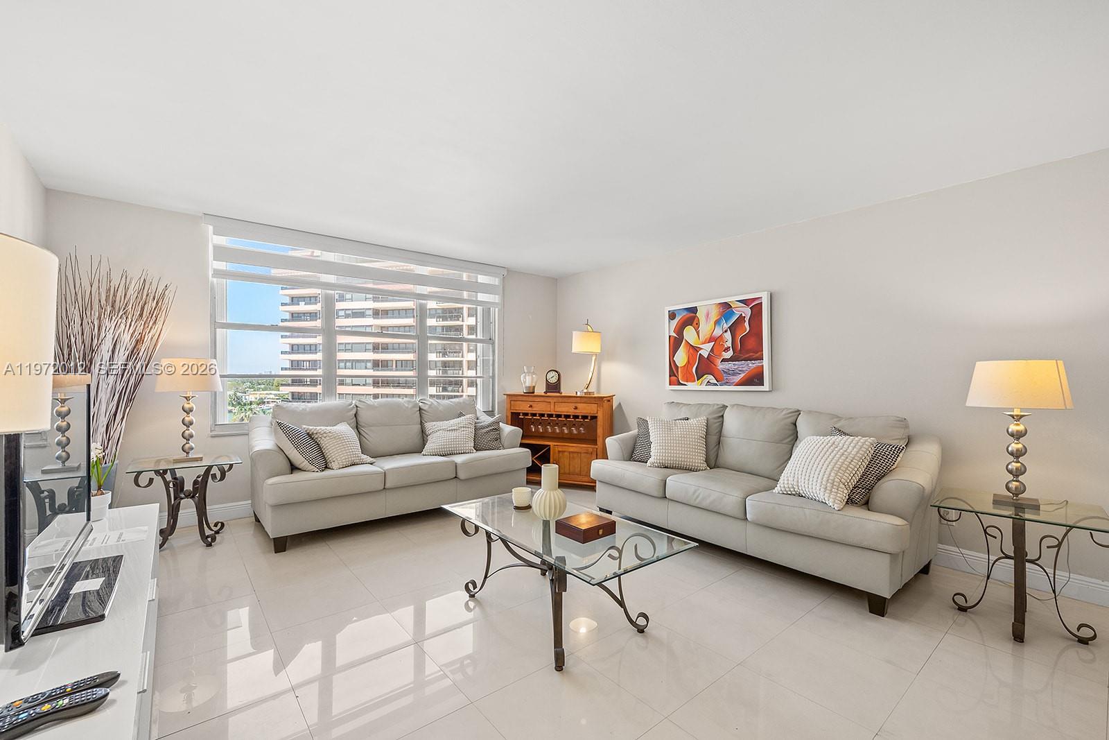 A living room features two light gray sofas, a glass coffee table, and tile flooring — 5161 Collins Ave # 910, Miami Beach FL 33140, MIAMI BEACH, FL