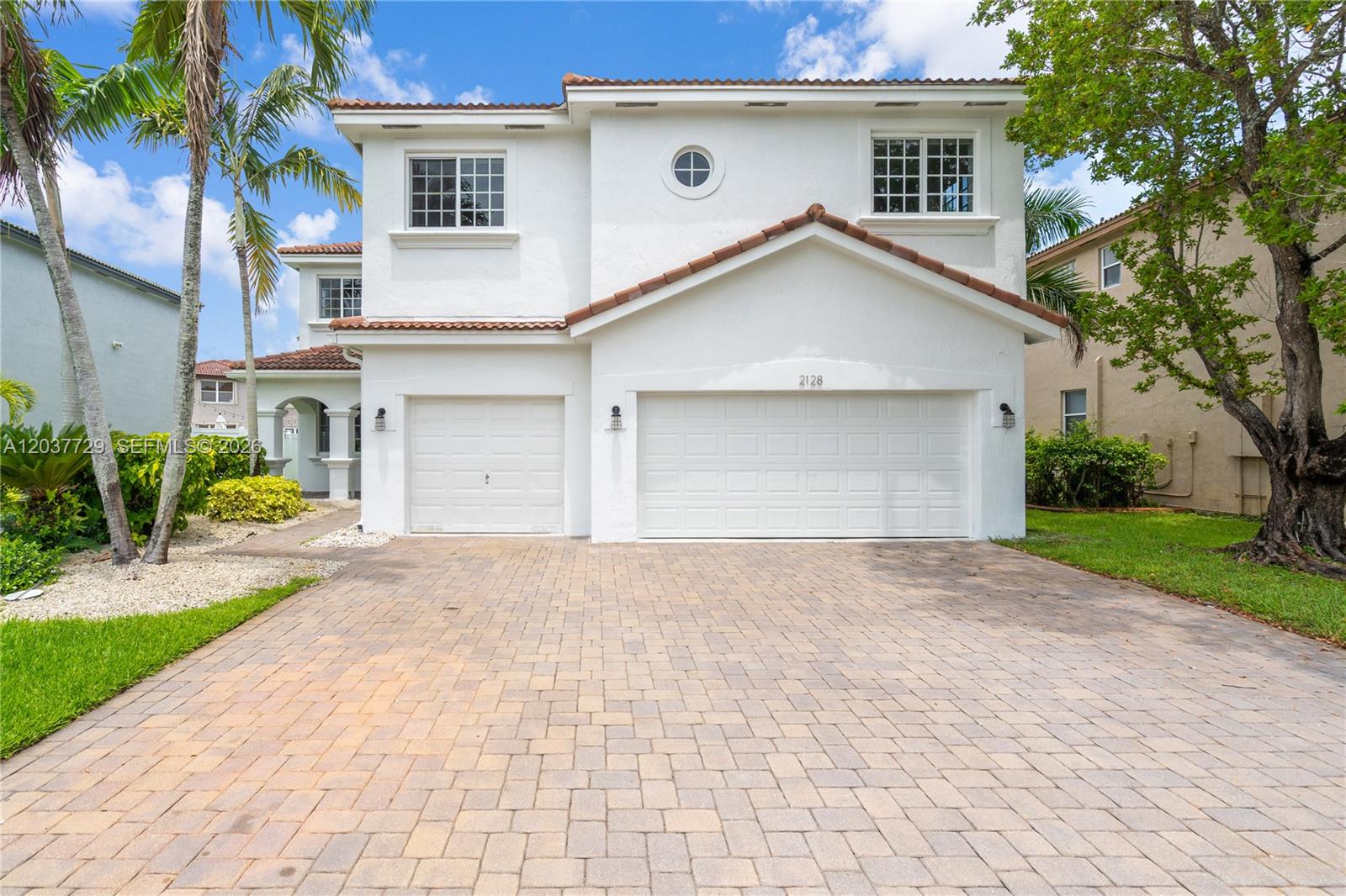 A two-story white stucco house features a three-car garage and a paved driveway — 2128 SW 176th Ter, Miramar FL 33029, MIRAMAR, FL