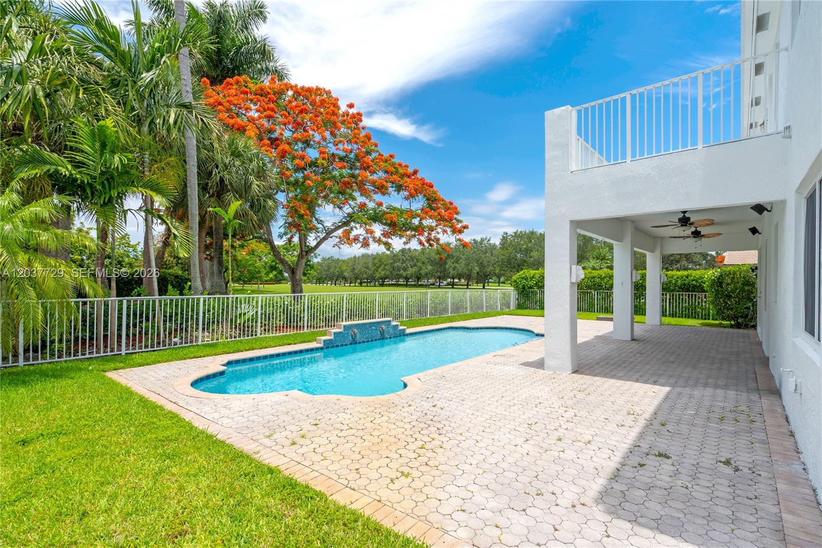 A backyard features a swimming pool, a paved patio, and a large flowering tree — 2128 SW 176th Ter, Miramar FL 33029, MIRAMAR, FL