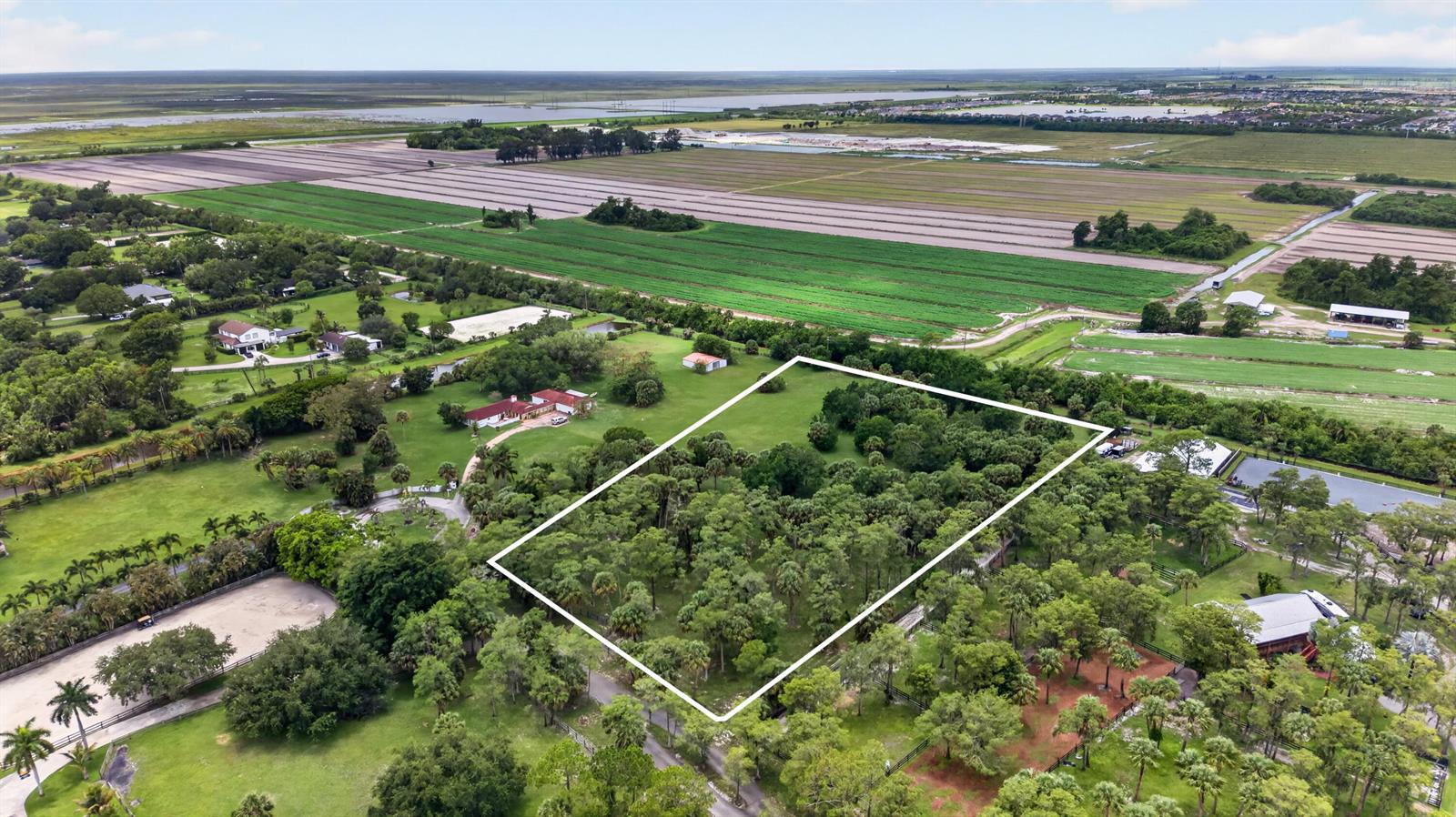 An aerial view shows a wooded lot outlined in white next to a rural property — 000 Foxtrail, Loxahatchee FL 33470, LOXAHATCHEE, FL