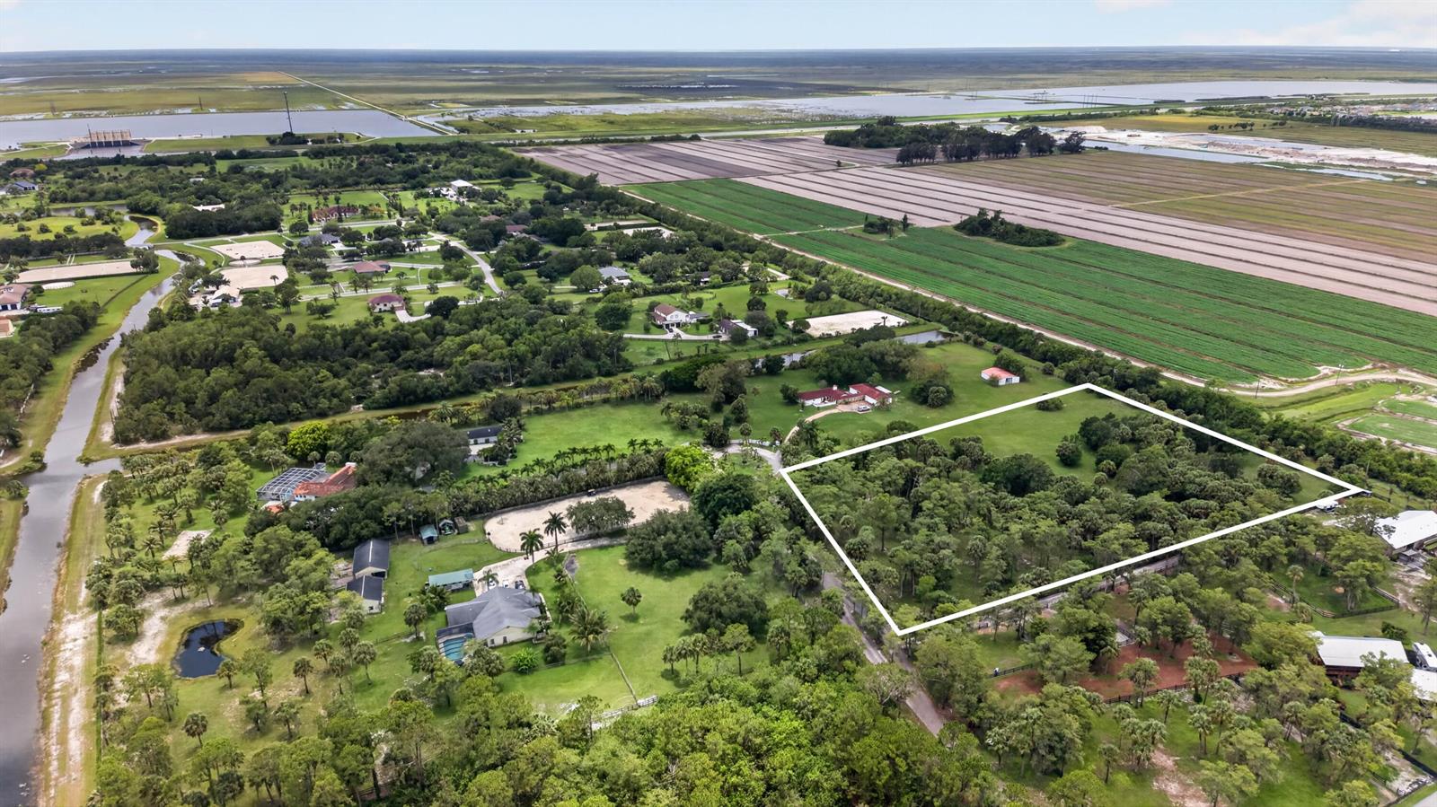 An aerial view shows a wooded lot outlined in white within a rural residential area — 000 Foxtrail, Loxahatchee FL 33470, LOXAHATCHEE, FL