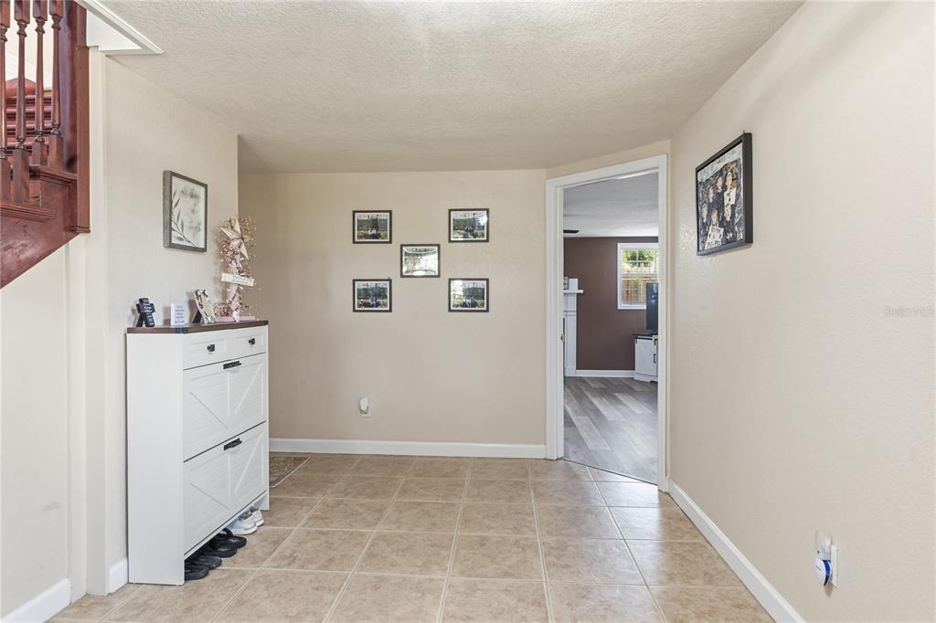 An entryway with tile flooring, a white shoe cabinet, and a doorway leading to another room — 1660 E MAIN STREET, BARTOW, FL