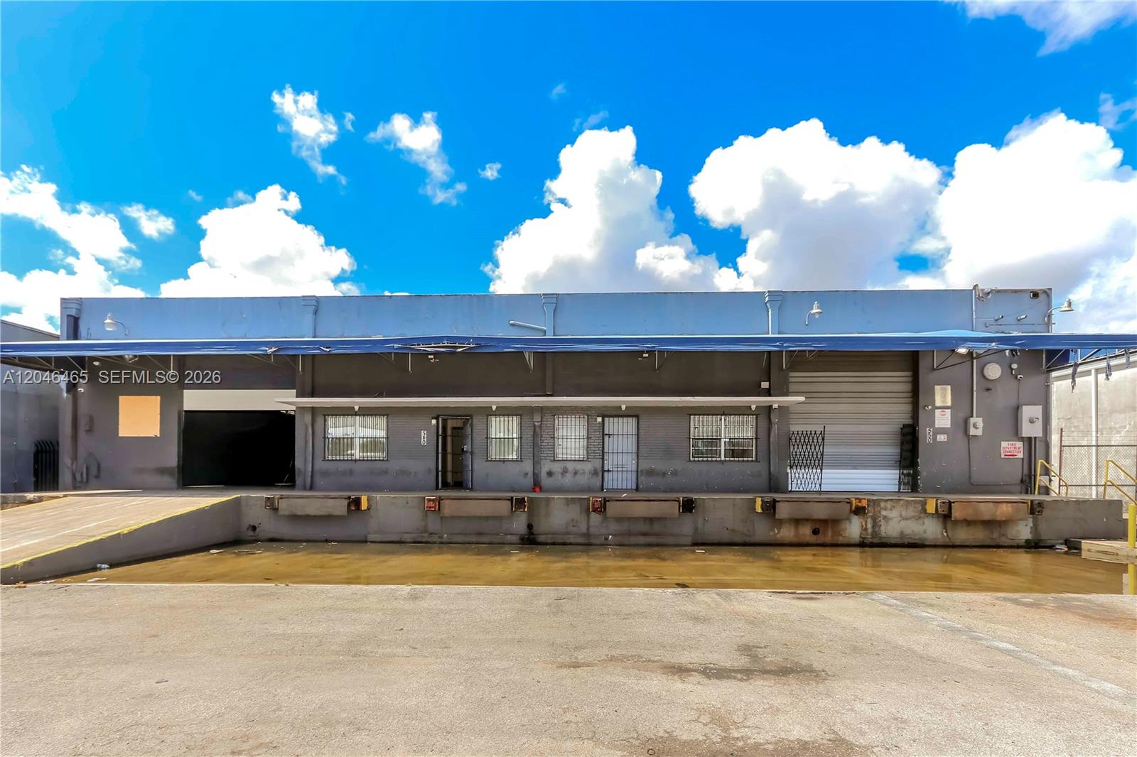 The exterior of a commercial warehouse building features multiple loading docks and a concrete ramp — 540 W 20th St, Hialeah FL 33010, HIALEAH, FL