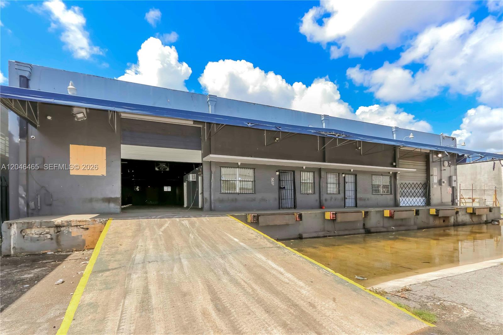 An exterior view of a warehouse building featuring a loading dock and a concrete ramp — 540 W 20th St, Hialeah FL 33010, HIALEAH, FL