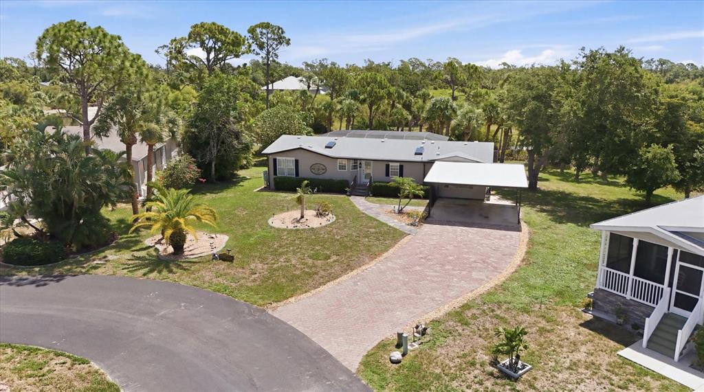 An aerial view shows a single-story house with a paved driveway and a carport — 9158 PINEHAVEN WAY, ENGLEWOOD, FL
