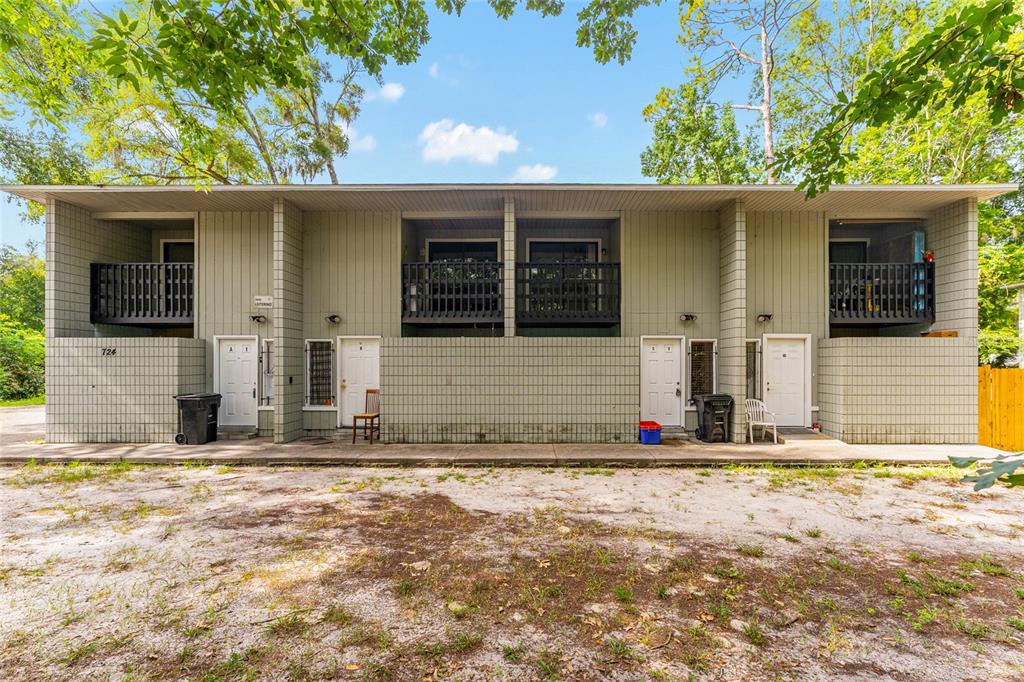 A two-story apartment building with a flat roof, balconies, and a dirt parking area — 724 SW 68TH TERRACE, GAINESVILLE, FL