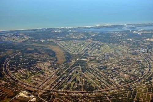 An aerial view shows a large, circular residential community with radiating streets and green spaces — 120 ALBATROSS ROAD, ROTONDA WEST, FL