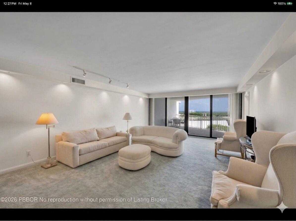 A living room features white furniture, gray carpeting, and a balcony with an ocean view — 3170 S Ocean Boulevard # 201n, Palm Beach FL 33480, PALM BEACH, FL