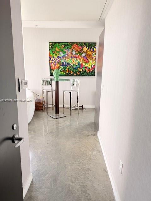 A small dining area with a glass table, two stools, and colorful wall art — 151 SE 1st St # 3010, Miami FL 33131, MIAMI, FL
