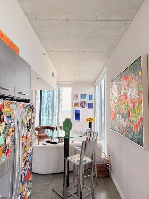 A modern apartment dining area features a glass table, metal stools, and a large painting — 151 SE 1st St # 3010, Miami FL 33131, MIAMI, FL