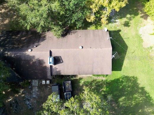 An aerial view shows the brown shingled roof of a house with two parked vehicles — 4705 KISSIMMEE PARK ROAD, ST CLOUD, FL