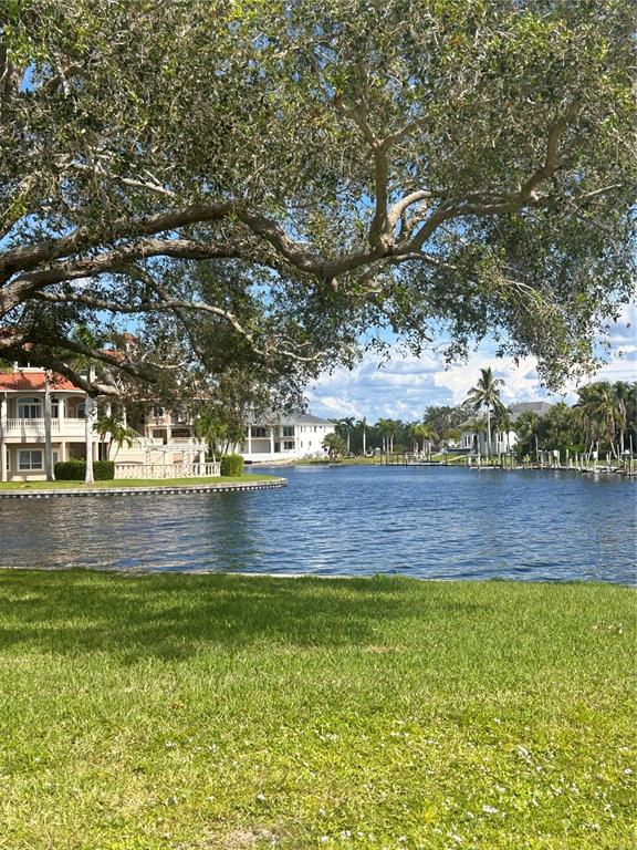 A view of a canal with large houses and trees from a grassy lawn — 143 CREEK DRIVE SE, PORT CHARLOTTE, FL