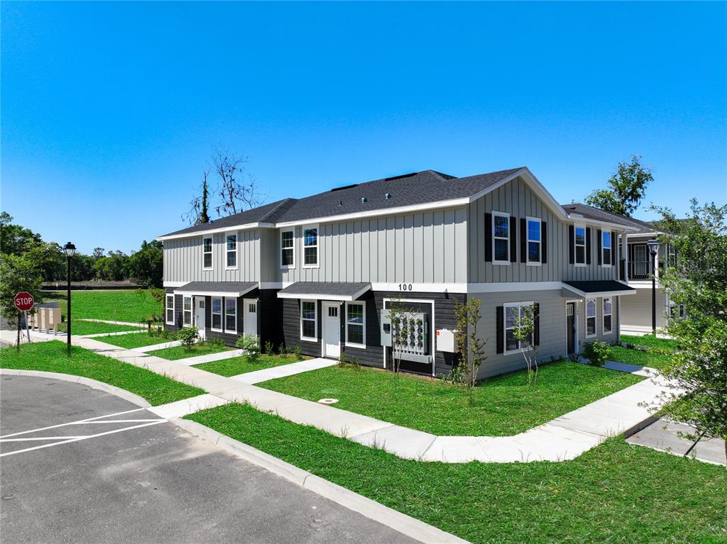 A two-story apartment building with gray siding and black shutters sits on a grassy lot — 3821 SW 43RD COURT, OCALA, FL
