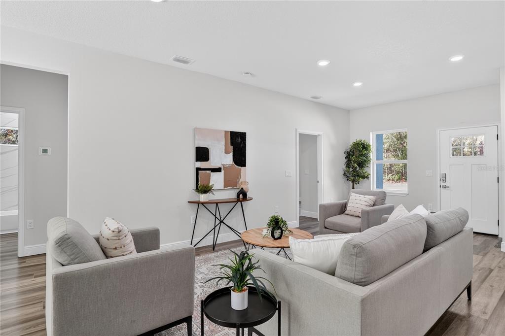 A living room features gray furniture, a round coffee table, and a console table — 10707 N HATARI DRIVE, CITRUS SPRINGS, FL
