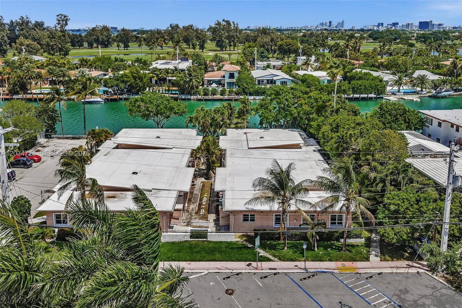 An aerial view shows two adjacent low-rise buildings next to a canal and golf course — 1795 Calais Dr, Miami Beach FL 33141, MIAMI BEACH, FL