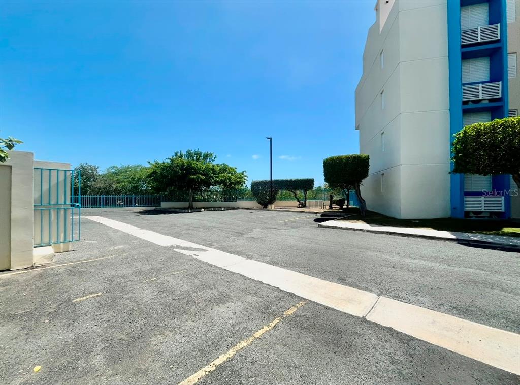 An outdoor parking lot sits beside a multi-story building with blue accents — 3301 N VISTAMAR EL COMBATE UNIT 206, CABO ROJO, PR