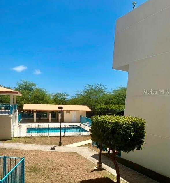 An outdoor view of a swimming pool area with a covered pavilion and surrounding trees — 3301 N VISTAMAR EL COMBATE UNIT 206, CABO ROJO, PR