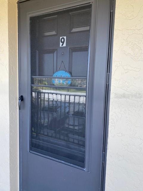 A dark gray storm door with a number nine sign and a decorative lighthouse plaque — 4024 OAKVIEW DRIVE UNIT I9, PORT CHARLOTTE, FL