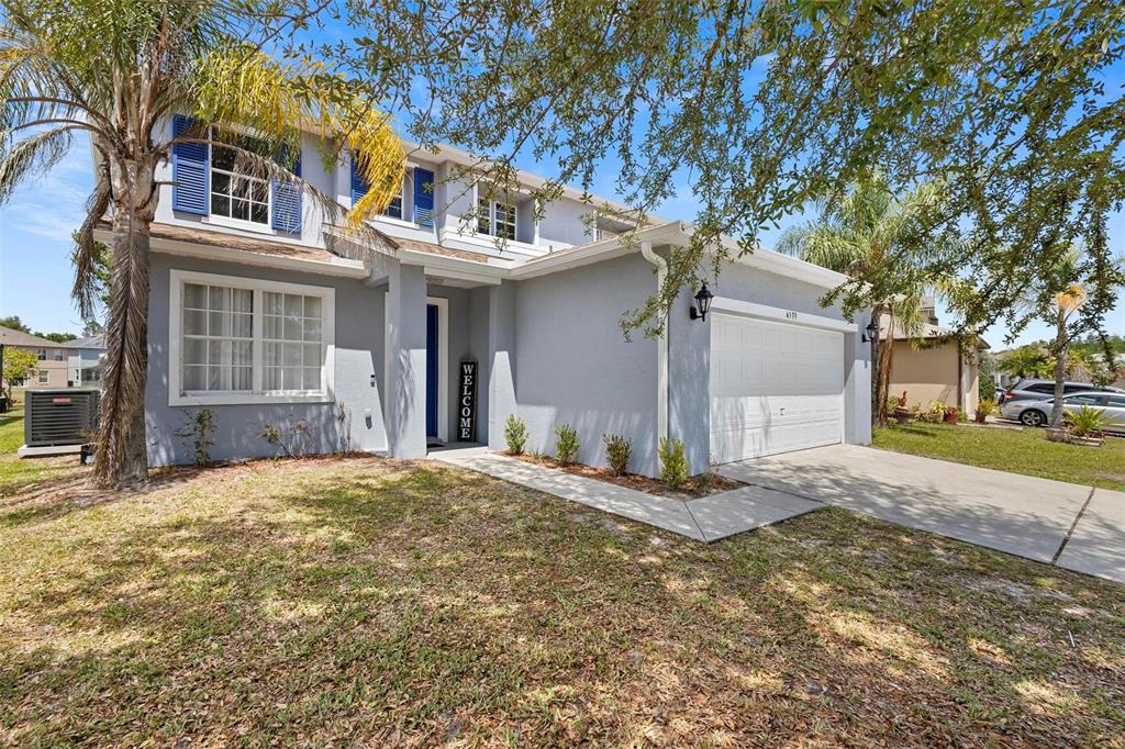 A two-story house with a gray stucco exterior, blue shutters, and a two-car garage — 4539 PHILADELPHIA CIRCLE, KISSIMMEE, FL