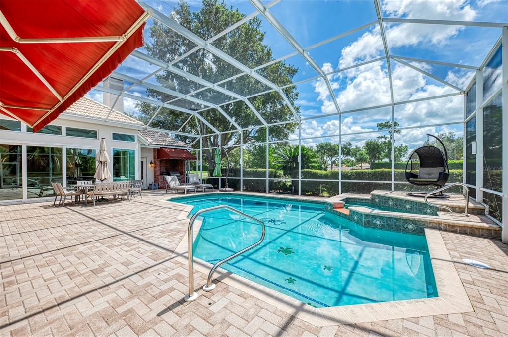 A screened-in patio features a swimming pool, a raised spa, and outdoor furniture — 7767 ALISTER MACKENZIE DRIVE, SARASOTA, FL