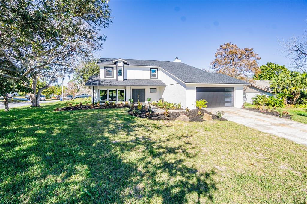 A concrete walkway leads to a covered entryway with a dark double door and bench — 6370 CONNIEWOOD SQUARE, NEW PORT RICHEY, FL