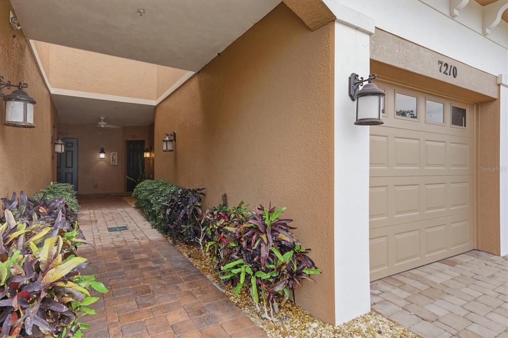 The exterior entryway features a dark gray door, a window, and a small potted plant — 7210 HAMILTON ROAD, BRADENTON, FL