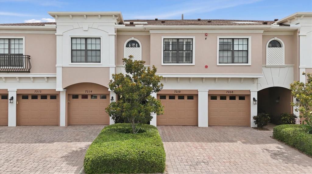 A paved walkway leads to two front doors under a covered entryway beside a garage — 7210 HAMILTON ROAD, BRADENTON, FL