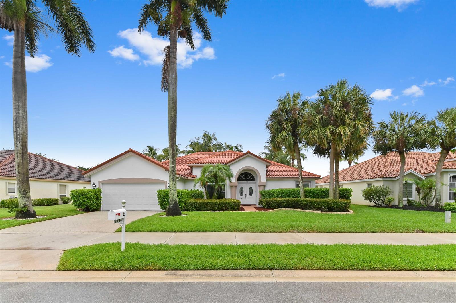 A single-story house with a white exterior, red tile roof, and palm trees in front — 7734 Belmont Drive, Lake Worth FL 33467, LAKE WORTH, FL