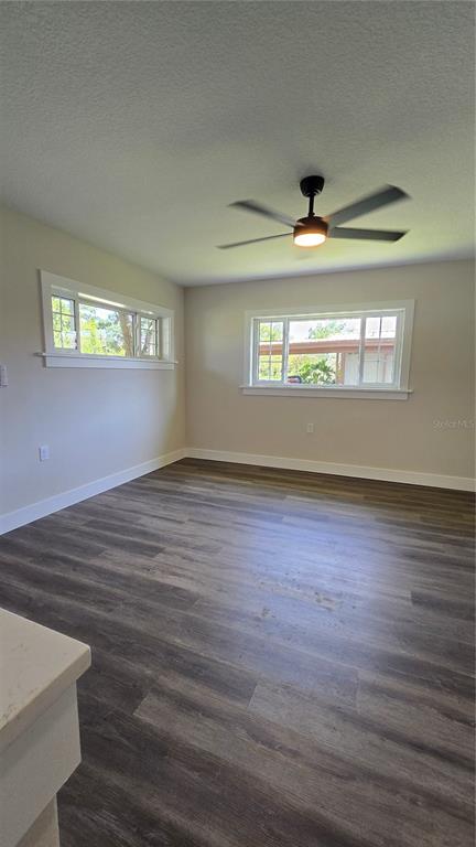 An empty room features light-colored walls, wood-look flooring, two windows, and a ceiling fan — 2709 ARC DRIVE, ORLANDO, FL