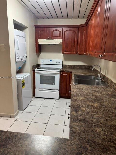 A kitchen features dark wood cabinets, a white stove, a stacked washer-dryer, and laminate countertops — 10000 NW 80th Ct # 2249, Hialeah Gardens FL 33016, HIALEAH GARDENS, FL