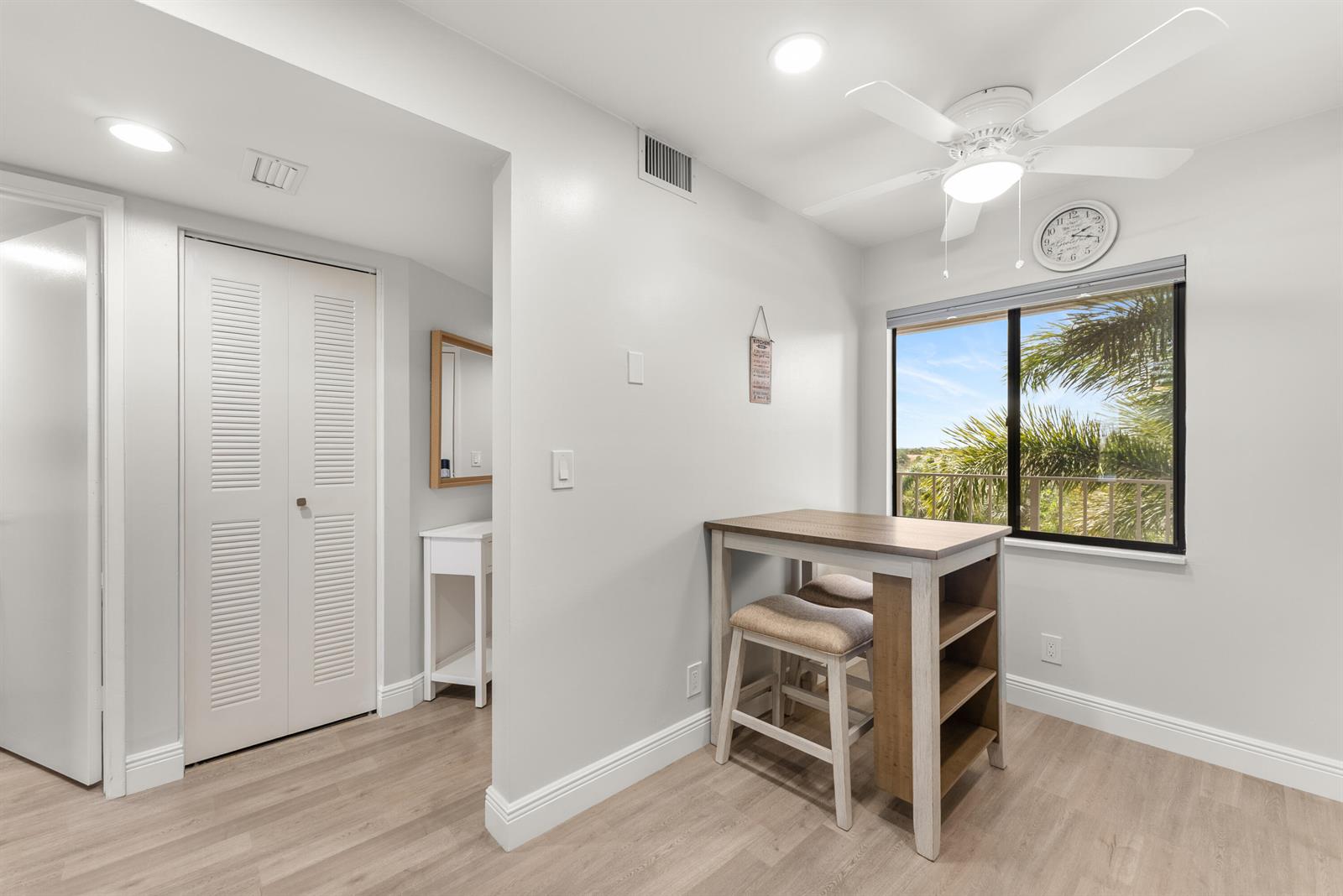 A dining area with a small table, stools, and a window overlooking palm trees — 14500 Stirling Way # 403, Delray Beach FL 33446, DELRAY BEACH, FL