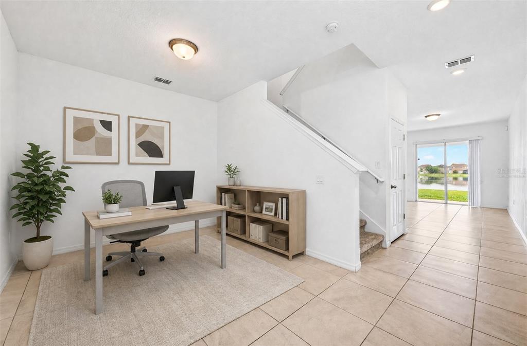 A home office with a desk, bookshelf, and stairs leading to an upper level — 15523 WILLOW ARBOR CIRCLE, ORLANDO, FL