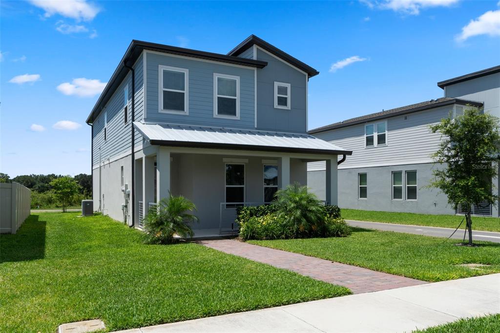 A two-story house with blue siding, a covered front porch, and a brick walkway — 14340 BRAEMAR STREET, WINTER GARDEN, FL