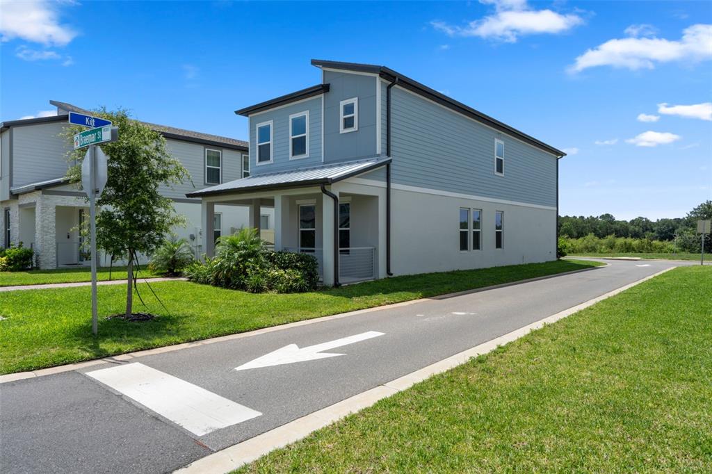 A two-story house with light blue siding and a covered front porch sits near a road — 14340 BRAEMAR STREET, WINTER GARDEN, FL