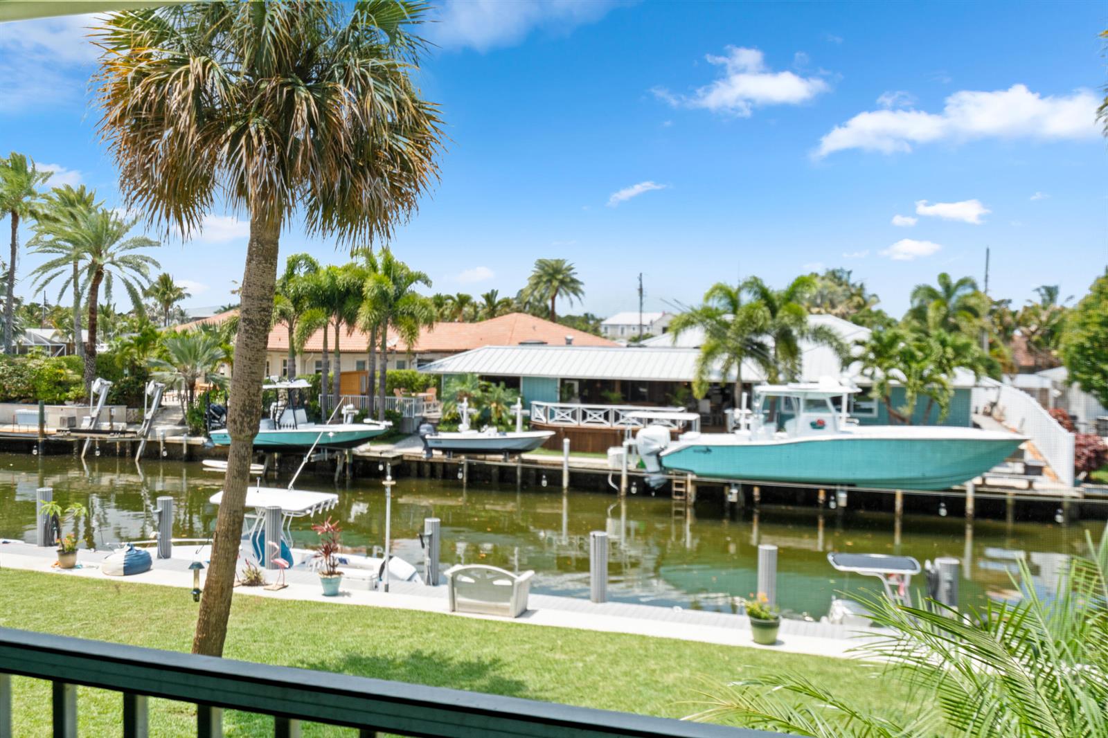 A view of a canal with several boats docked behind houses surrounded by palm trees — 249 Center Street # 2c, Jupiter FL 33458, JUPITER, FL