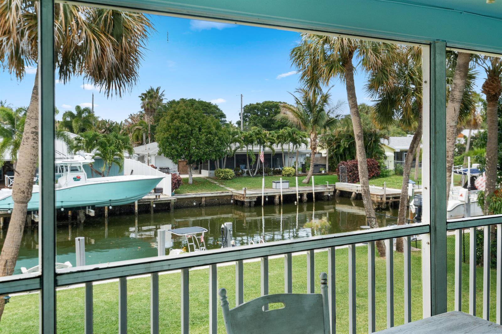 A view from a screened-in porch overlooking a canal with boats and palm trees — 249 Center Street # 2c, Jupiter FL 33458, JUPITER, FL