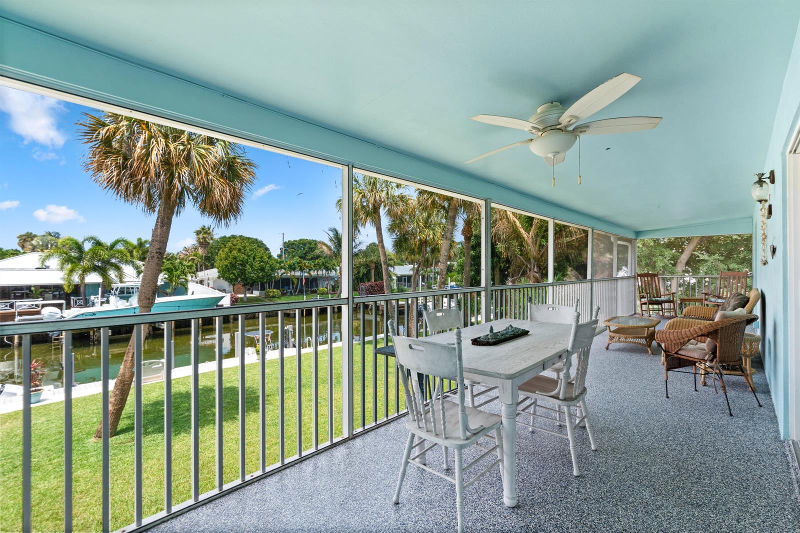 A screened-in porch features a dining set, wicker furniture, and a view of a canal — 249 Center Street # 2c, Jupiter FL 33458, JUPITER, FL