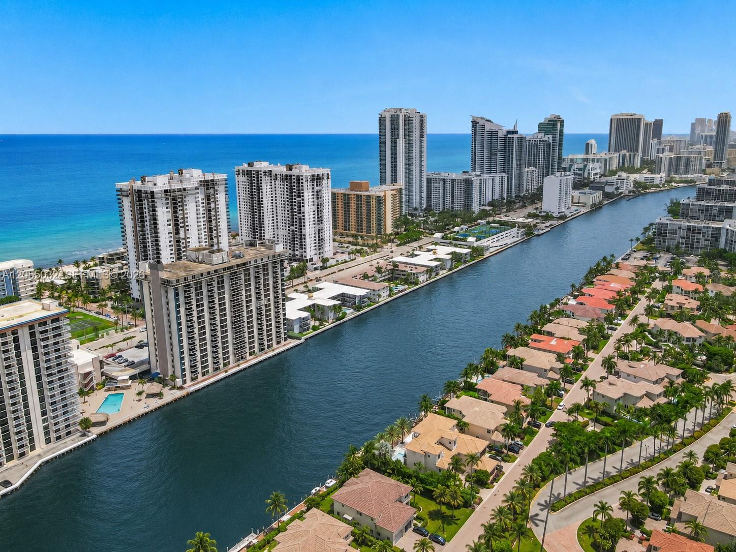 An aerial view shows a canal separating high-rise apartment buildings from a residential neighborhood — 1600 S Ocean Dr # 18B, Hollywood FL 33019, HOLLYWOOD, FL