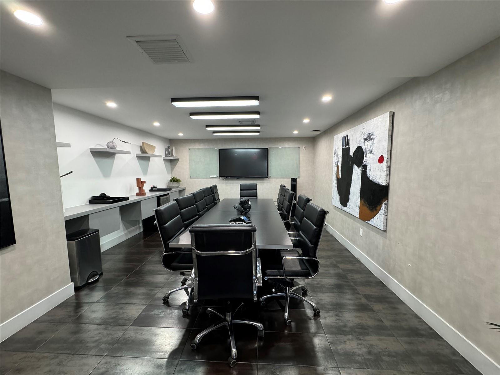 A modern conference room features a long table, black leather chairs, and large abstract art — 2719 Hollywood Boulevard, Hollywood FL 33020, HOLLYWOOD, FL