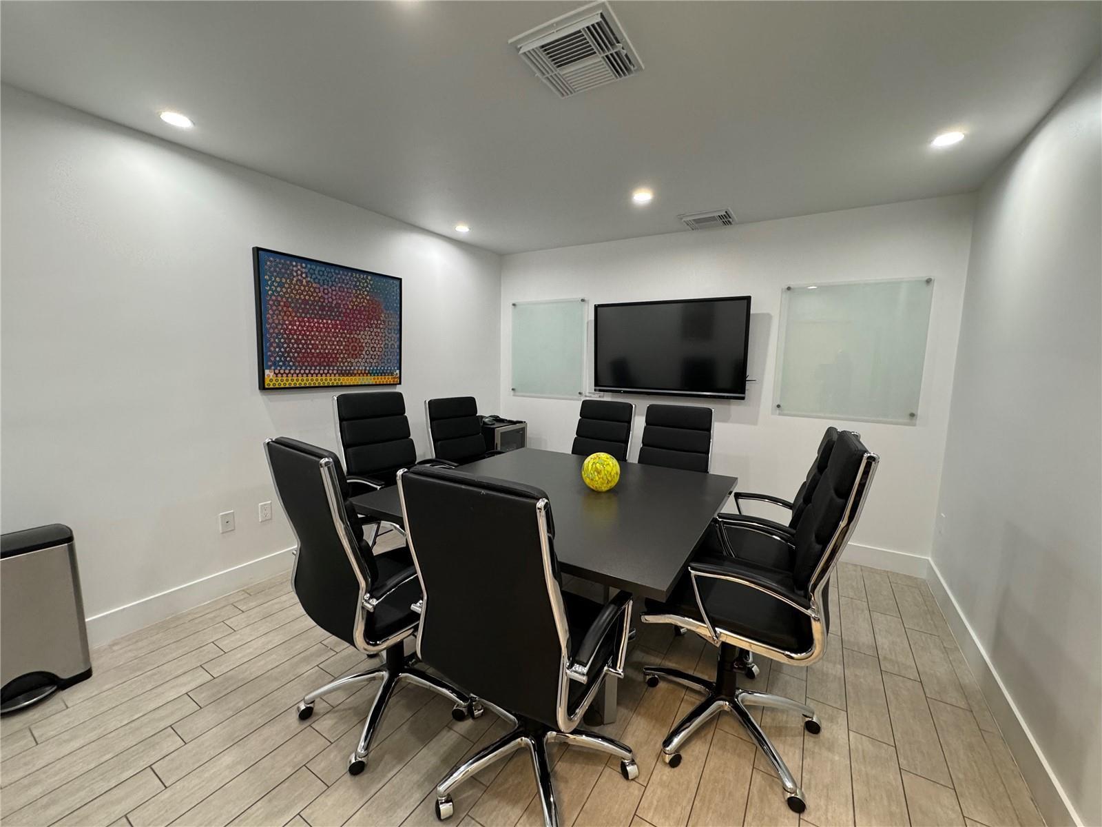 A conference room features a black table, six black chairs, a television, and white walls — 2719 Hollywood Boulevard, Hollywood FL 33020, HOLLYWOOD, FL