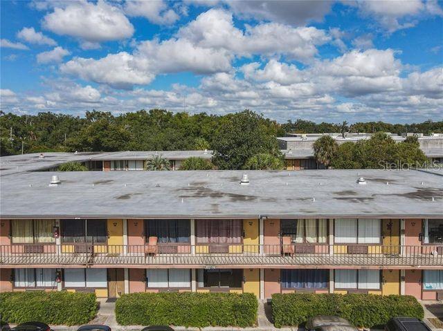An exterior view of a multi-story apartment building with a flat roof and balconies — 7900 S ORANGE BLOSSOM TRAIL UNIT 2097, ORLANDO, FL