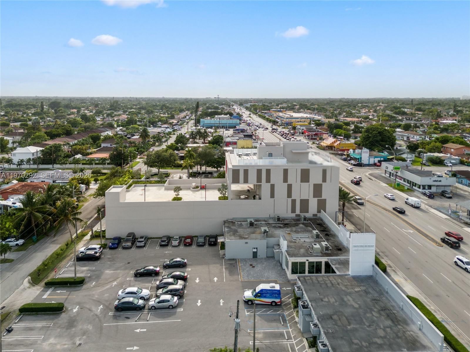 An aerial view shows a modern commercial building with a parking lot and surrounding streets — 8966 Bird Road, Miami FL 33165, MIAMI, FL