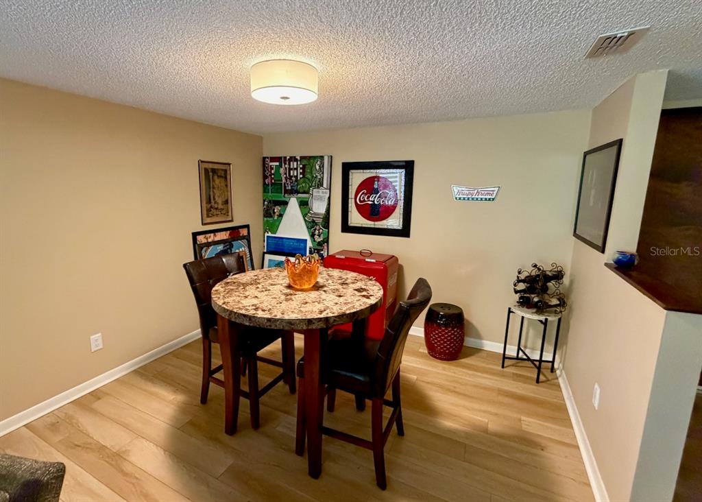 A dining area features a round table, four chairs, and vintage-style wall decor — 13604 S VILLAGE DRIVE UNIT 314, TAMPA, FL