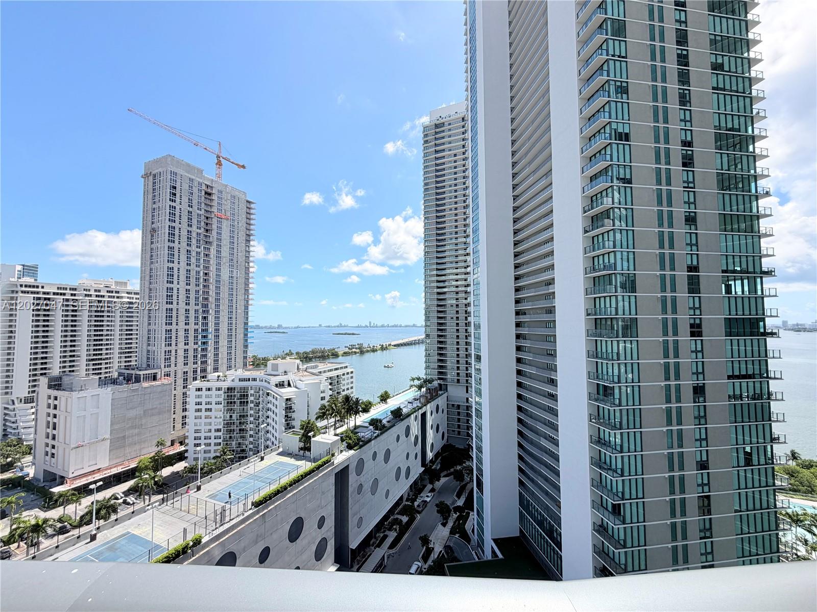 A high-angle view shows multiple modern high-rise buildings and a tennis court near the water — 501 NE 31st St # 1804, Miami FL 33137, MIAMI, FL