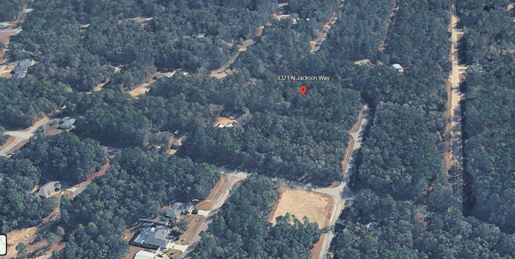 This aerial view shows a wooded residential lot marked with a red location pin — 9321 N JACKSON WAY, CITRUS SPRINGS, FL