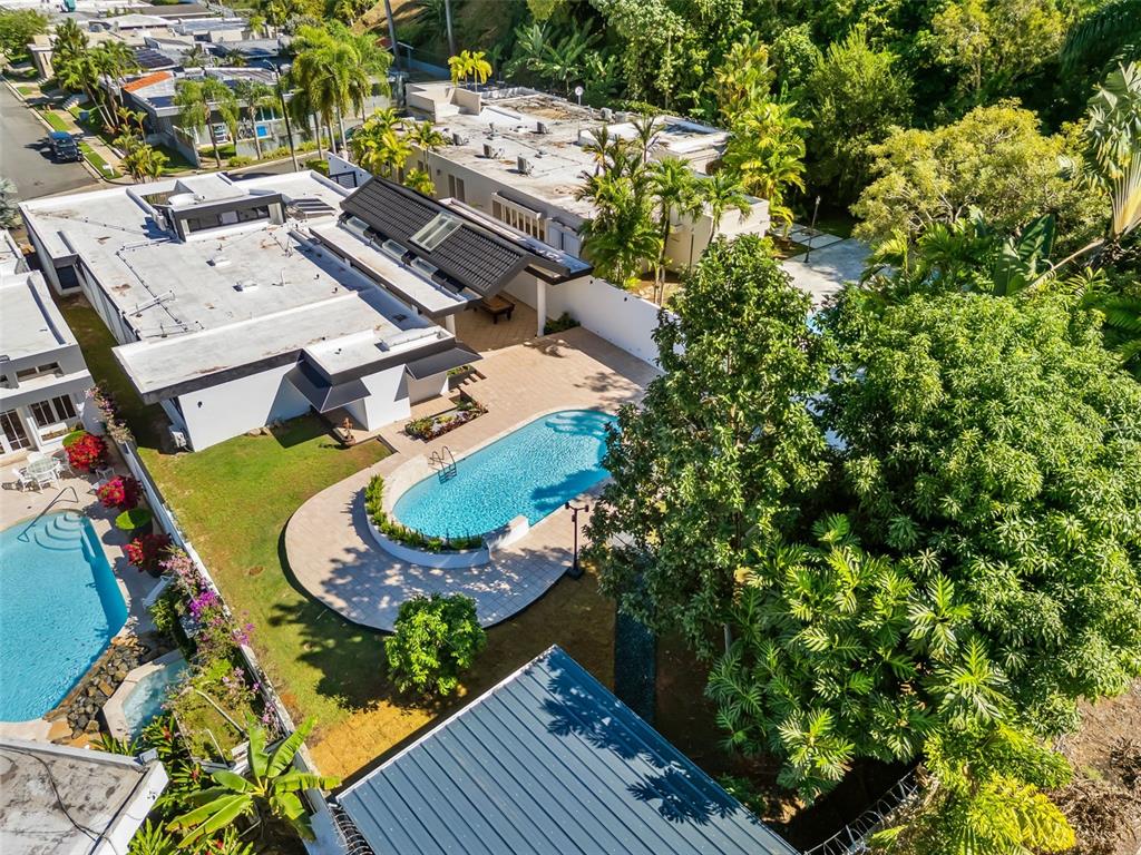 An aerial view shows a modern house with a swimming pool and lush green landscaping — 3 GARDEN HILLS ESTATES UNIT 12, GUAYNABO, PR