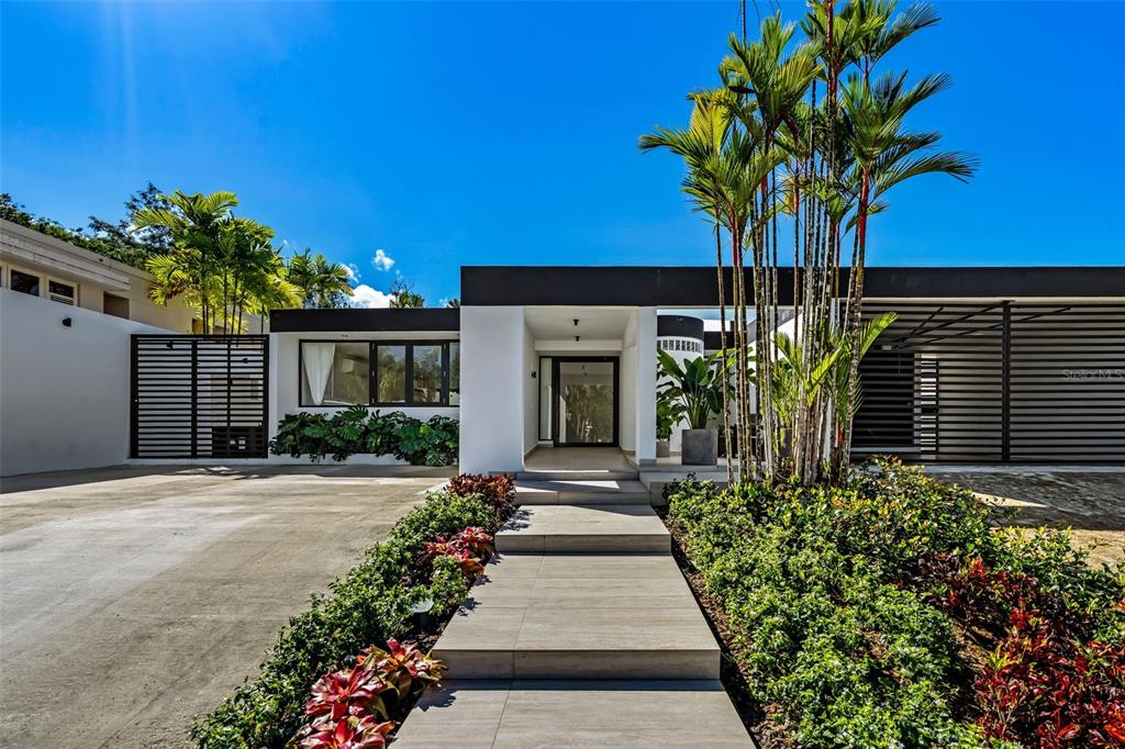 A modern, flat-roofed house with a paved walkway leading to a central glass entryway — 3 GARDEN HILLS ESTATES UNIT 12, GUAYNABO, PR