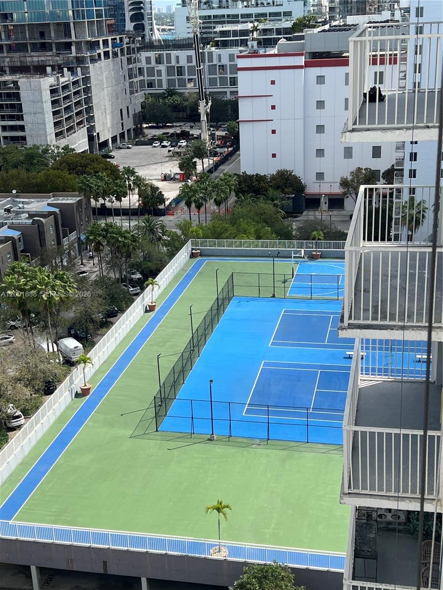 An elevated view shows a blue tennis court surrounded by a green perimeter on a deck — 850 N Miami Ave # 1806, Miami FL 33136, MIAMI, FL